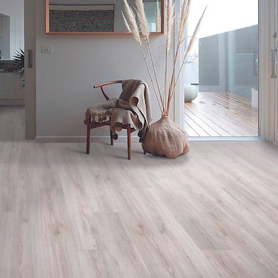 light wood look laminate floors in a hallway with chair and plant