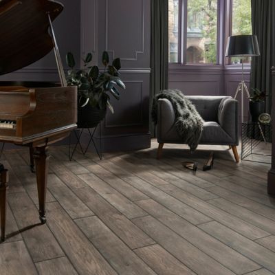 luxury vinyl plank floors in a rustic living room with chair and piano